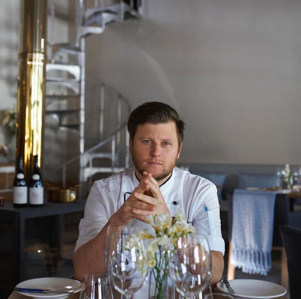 Male chef sitting at the table.